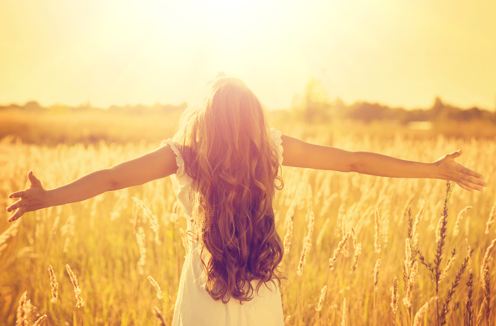 Girl-standing-with-open-arms-under-SUNlight - Transitions Chiropractic  Newcastle